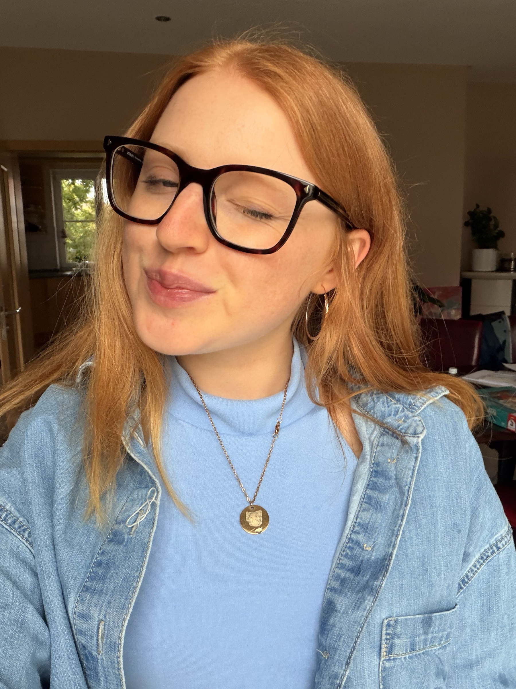 Julia in Jeansjacke, ruhig lächelnd